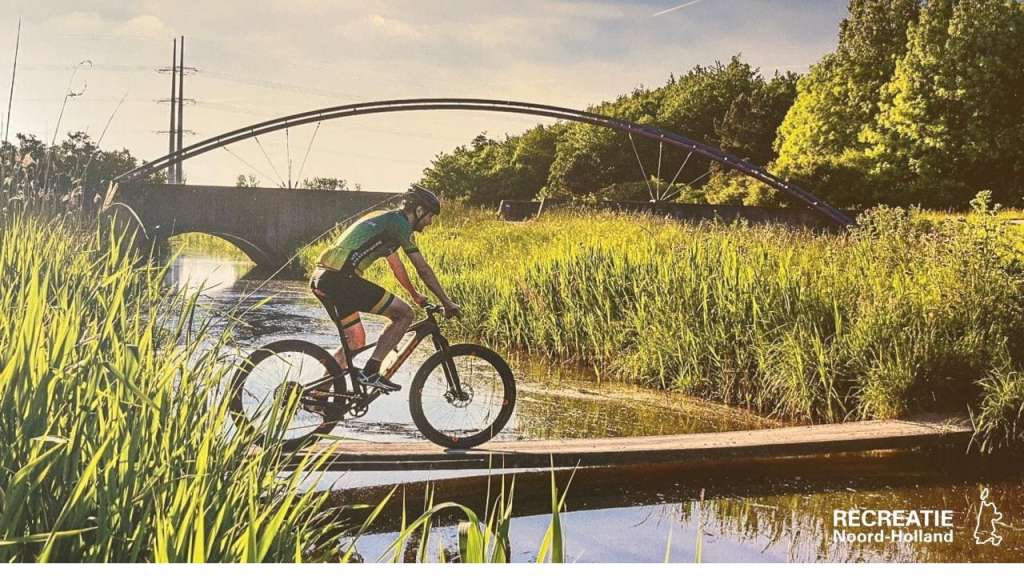 Mountainbiker steekt water over via fietsbrug Mountainbiker steekt water over via fietsbrug