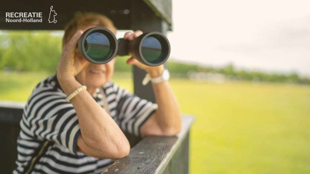 Mevrouw met verrekijker op een uitkijktoren Mevrouw met verrekijker op een uitkijktoren