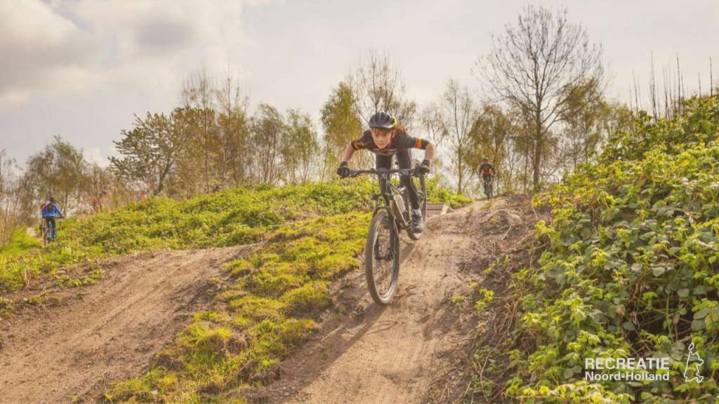 Jongen op mountainbike rijdt heuvel af